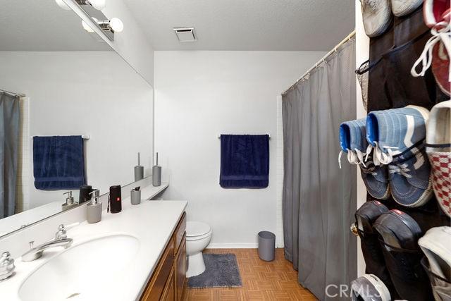 full bath featuring a shower with shower curtain, visible vents, vanity, and toilet