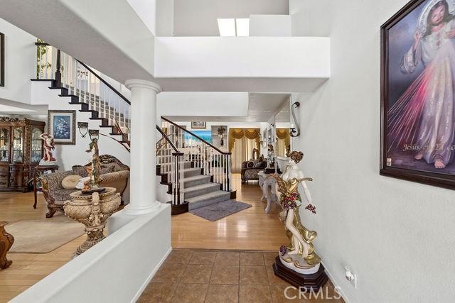 foyer entrance with ornate columns, tile patterned flooring, and stairs