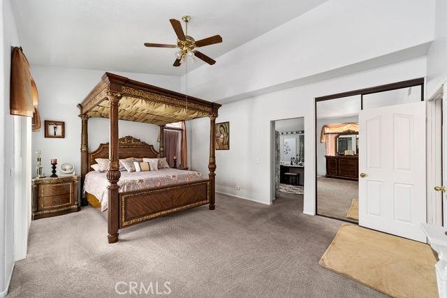 bedroom featuring carpet floors, a ceiling fan, and lofted ceiling