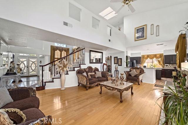 living area with visible vents, ceiling fan, stairs, french doors, and light wood-style floors