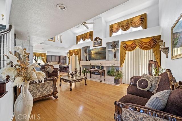 living area featuring a textured ceiling, a high ceiling, and wood finished floors