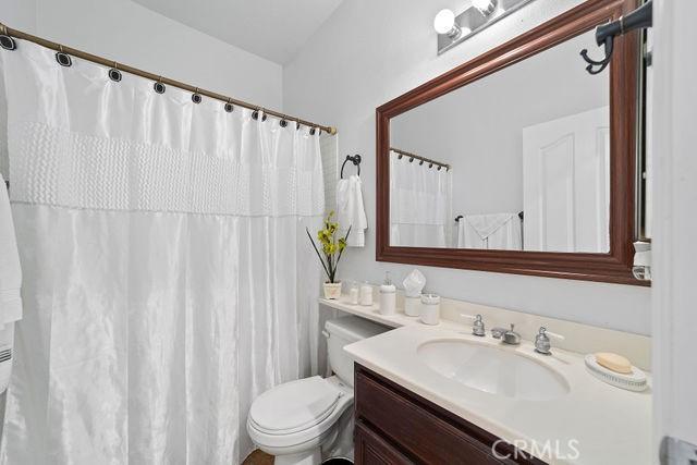 bathroom featuring toilet, a shower with curtain, and vanity