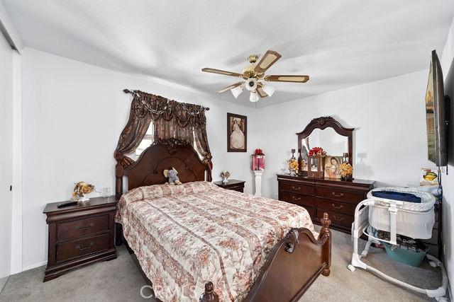 carpeted bedroom with ceiling fan and a closet