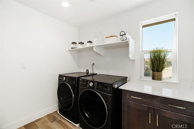 laundry area featuring cabinet space, baseboards, wood finished floors, separate washer and dryer, and recessed lighting