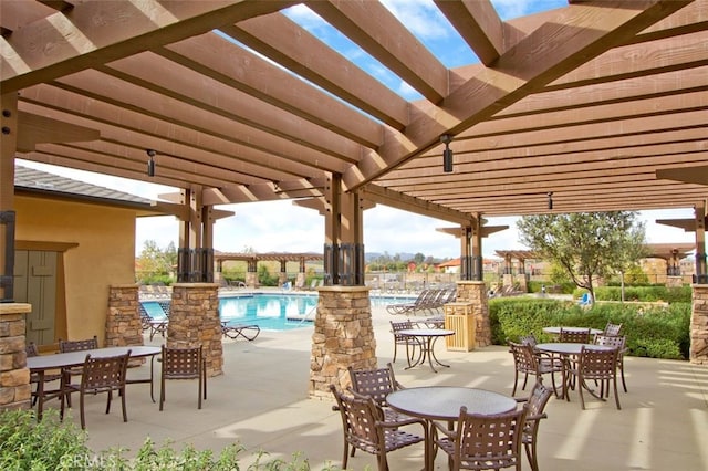 view of patio / terrace with outdoor dining area, a community pool, and a pergola