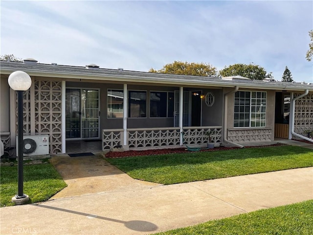 view of front of property featuring ac unit and a front lawn