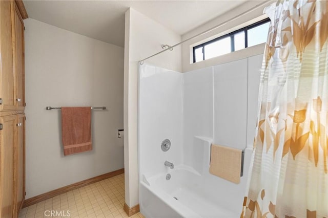 bathroom with shower / bath combination and baseboards