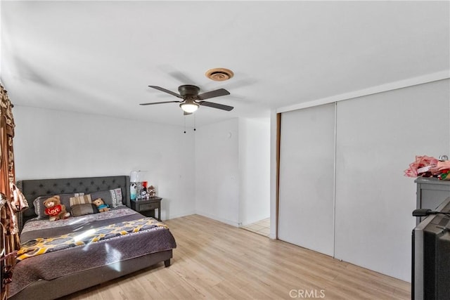 bedroom featuring light wood-style floors, a closet, visible vents, and a ceiling fan