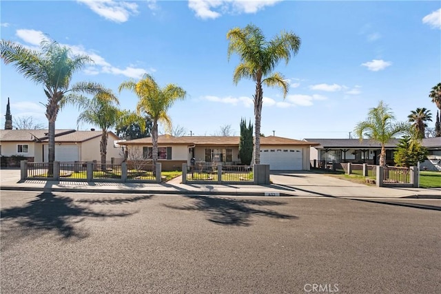 view of front of home with concrete driveway, a fenced front yard, an attached garage, and a gate