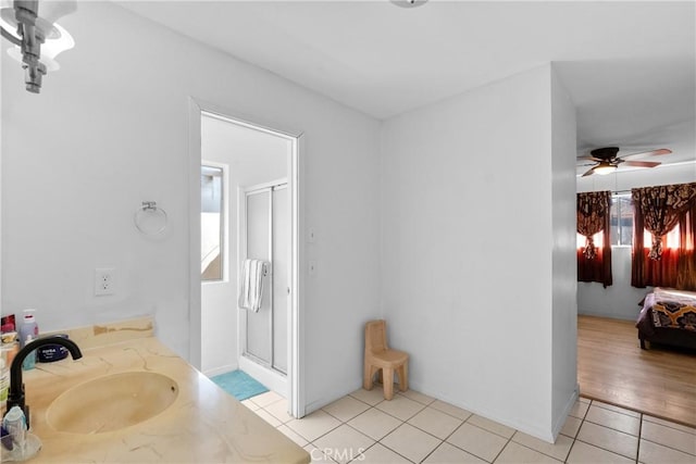 full bathroom with a ceiling fan, a stall shower, a sink, and tile patterned floors