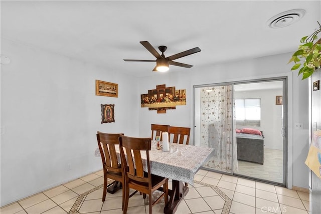 dining room with light tile patterned floors, visible vents, and a ceiling fan