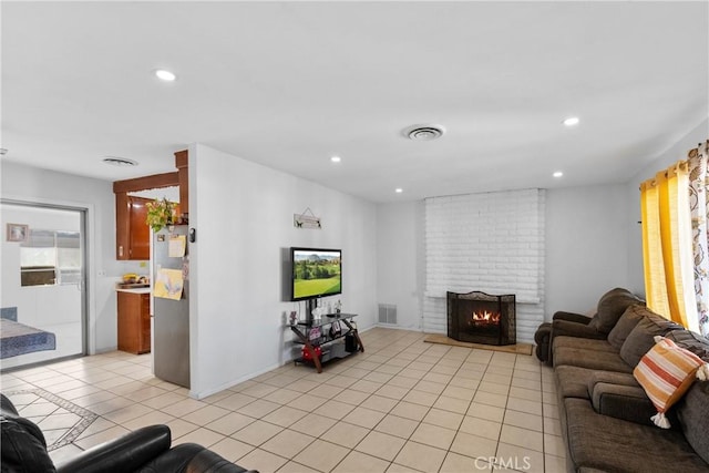 living area with recessed lighting, a brick fireplace, visible vents, and light tile patterned floors