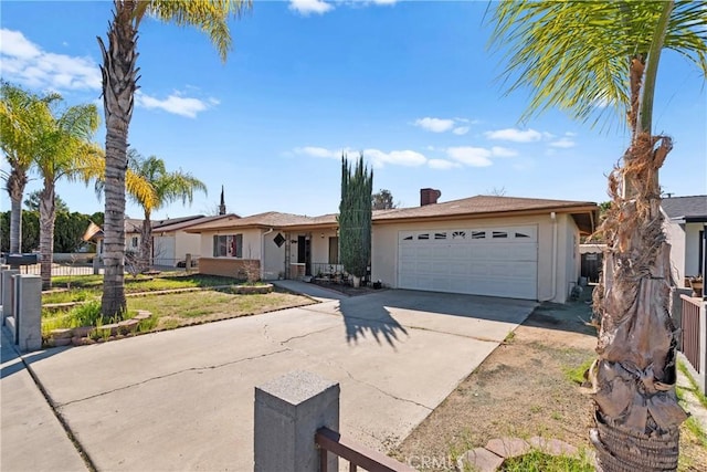 single story home featuring driveway, an attached garage, fence, and stucco siding