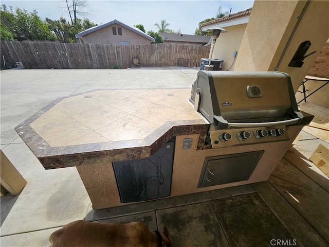 view of patio / terrace featuring central air condition unit, fence, and exterior kitchen