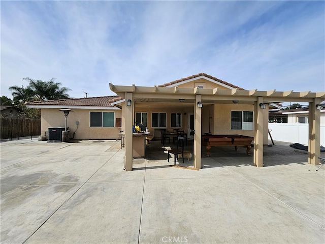 rear view of property featuring a patio area, fence, and stucco siding