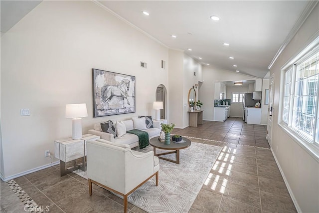 living room with arched walkways, baseboards, lofted ceiling, and crown molding