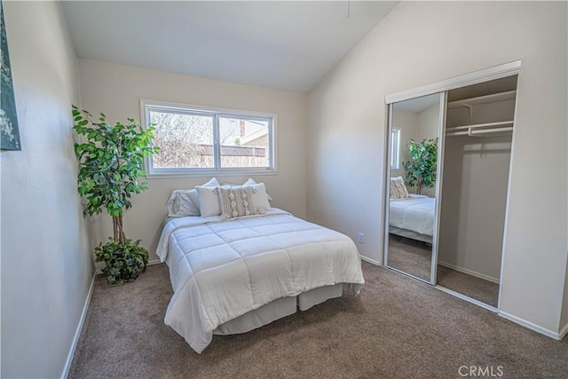 carpeted bedroom with vaulted ceiling, a closet, and baseboards