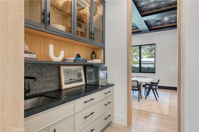 4050 Contera Rd, Encino, CA 91436 - bar featuring a sink, stainless steel microwave, light wood finished floors, and baseboards