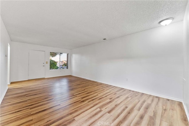 4738 Knoll Wood Ct, Oceanside, CA 92056 - empty room featuring a textured ceiling, light wood-style floors, and baseboards