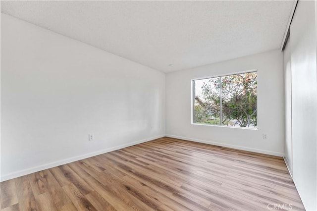 4738 Knoll Wood Ct, Oceanside, CA 92056 - empty room with light wood-style floors, baseboards, and a textured ceiling