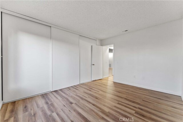 4738 Knoll Wood Ct, Oceanside, CA 92056 - unfurnished bedroom featuring light wood-type flooring, a textured ceiling, and a closet