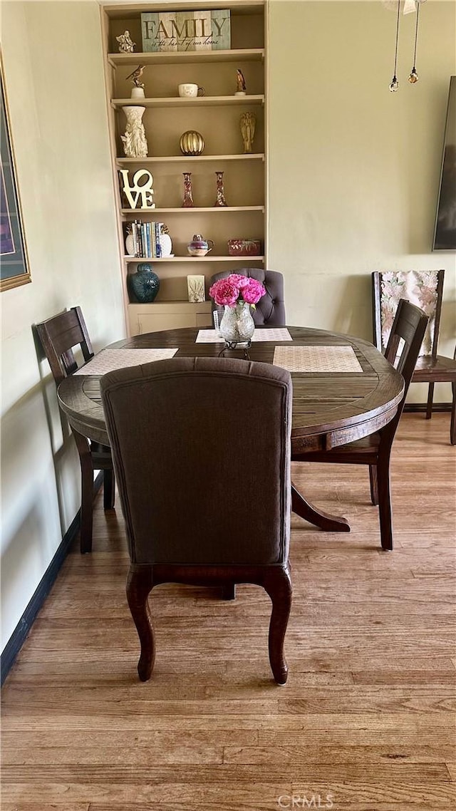 dining room featuring baseboards and wood finished floors