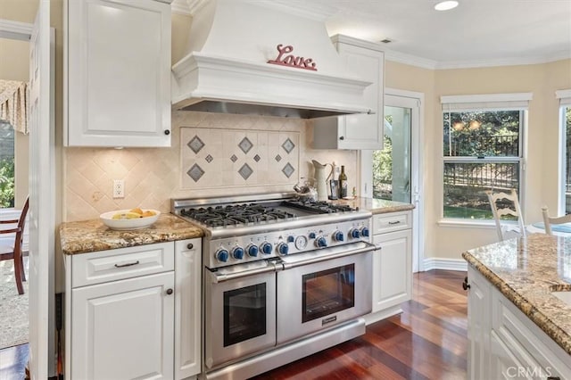 kitchen with white cabinetry, custom exhaust hood, range with two ovens, and crown molding