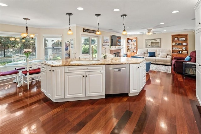 kitchen with dark wood-style flooring, decorative light fixtures, stainless steel dishwasher, white cabinets, and a sink