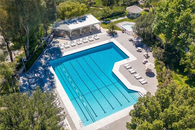 community pool with a gazebo and a patio