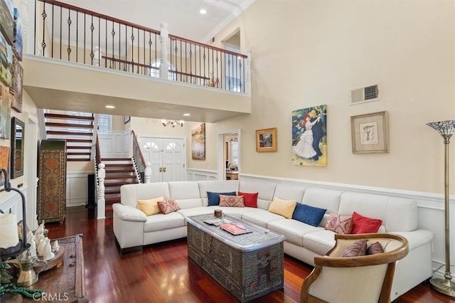 living room with visible vents, wainscoting, stairway, wood finished floors, and a decorative wall