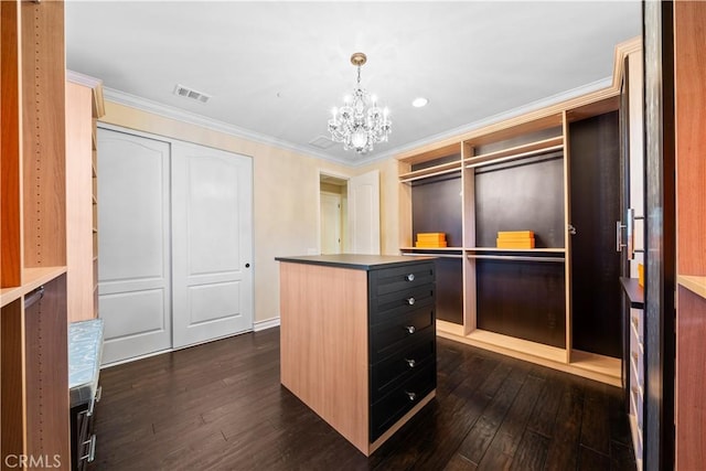 walk in closet featuring a notable chandelier, visible vents, and dark wood-type flooring