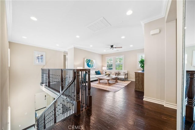 hall with baseboards, dark wood-style flooring, an upstairs landing, and crown molding