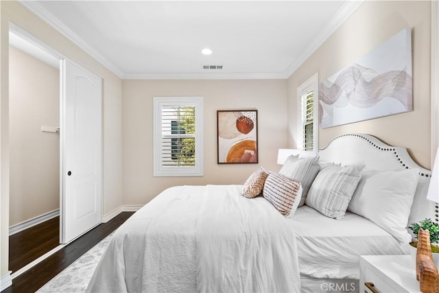 bedroom featuring baseboards, dark wood finished floors, visible vents, and crown molding