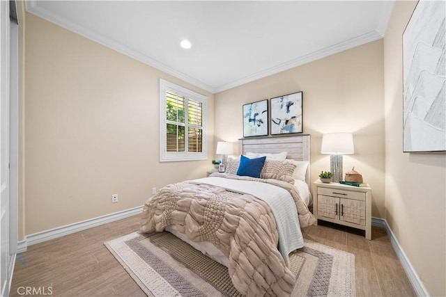 bedroom with baseboards, light wood-style floors, and crown molding