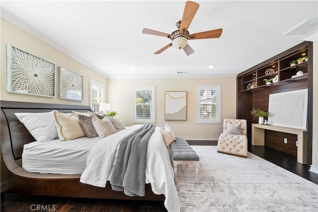 bedroom with ornamental molding, wood finished floors, and a ceiling fan