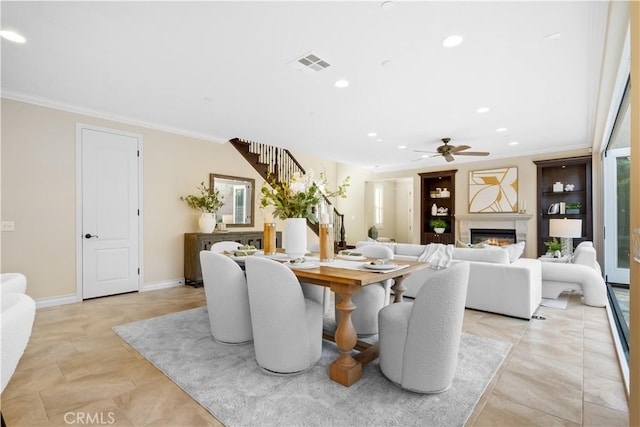 dining room with visible vents, a glass covered fireplace, ornamental molding, stairs, and recessed lighting