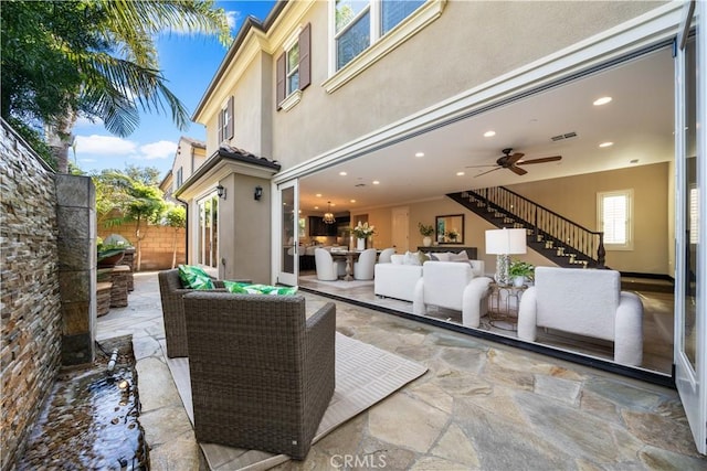 view of patio with stairway, outdoor lounge area, fence, and visible vents