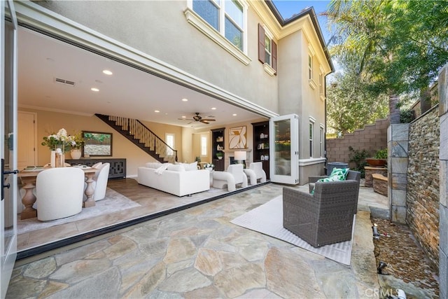 view of patio with stairway, outdoor lounge area, fence, and visible vents