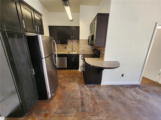 kitchen with baseboards, decorative backsplash, light countertops, black appliances, and a sink