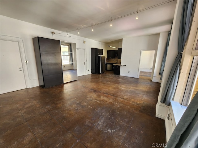 unfurnished living room featuring track lighting