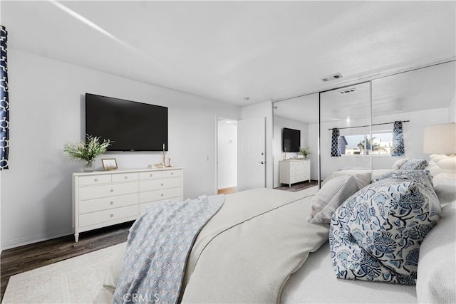 bedroom featuring wood finished floors, visible vents, and baseboards