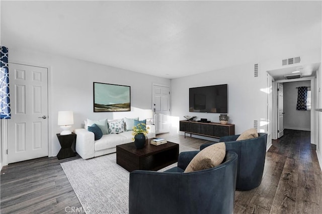 living area with dark wood-style flooring and visible vents