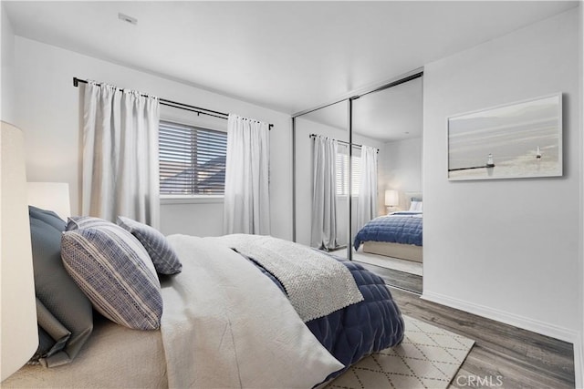 bedroom with baseboards and wood finished floors