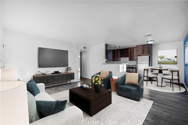 living area featuring dark wood-type flooring and visible vents