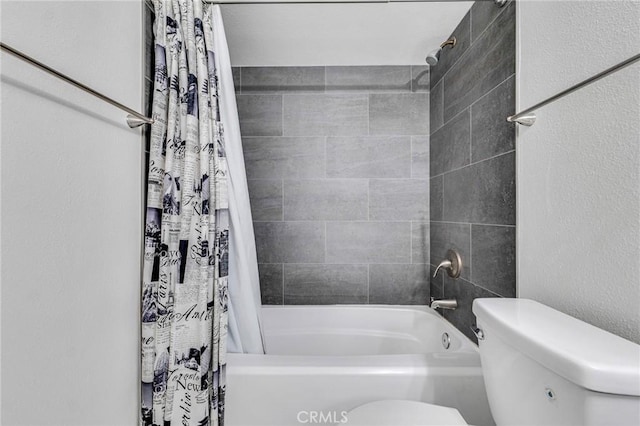 bathroom with a textured wall, shower / bath combo, and toilet