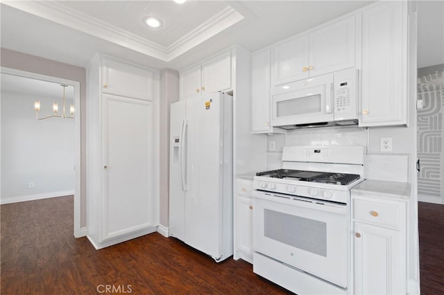 kitchen with white appliances, dark wood-type flooring, white cabinets, light countertops, and a raised ceiling