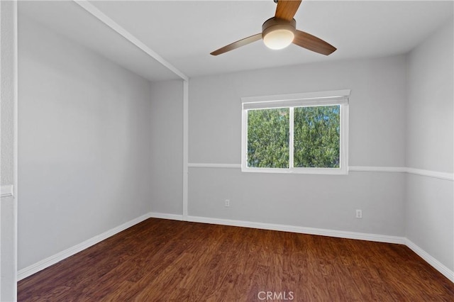 spare room featuring ceiling fan, wood finished floors, and baseboards