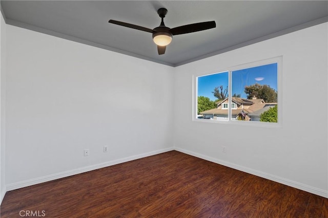 empty room with a ceiling fan, baseboards, and wood finished floors