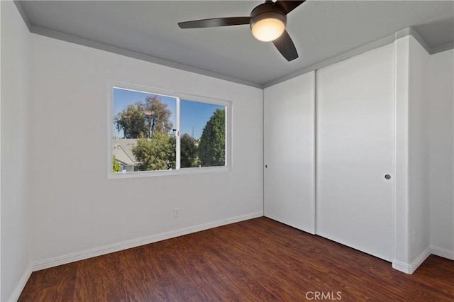 empty room with ceiling fan, baseboards, and wood finished floors