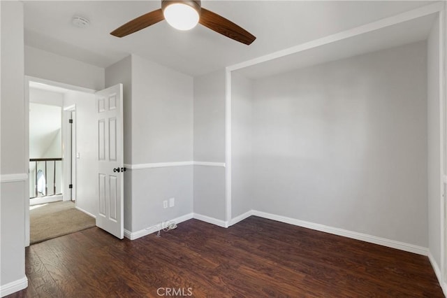 spare room featuring ceiling fan, baseboards, and wood finished floors